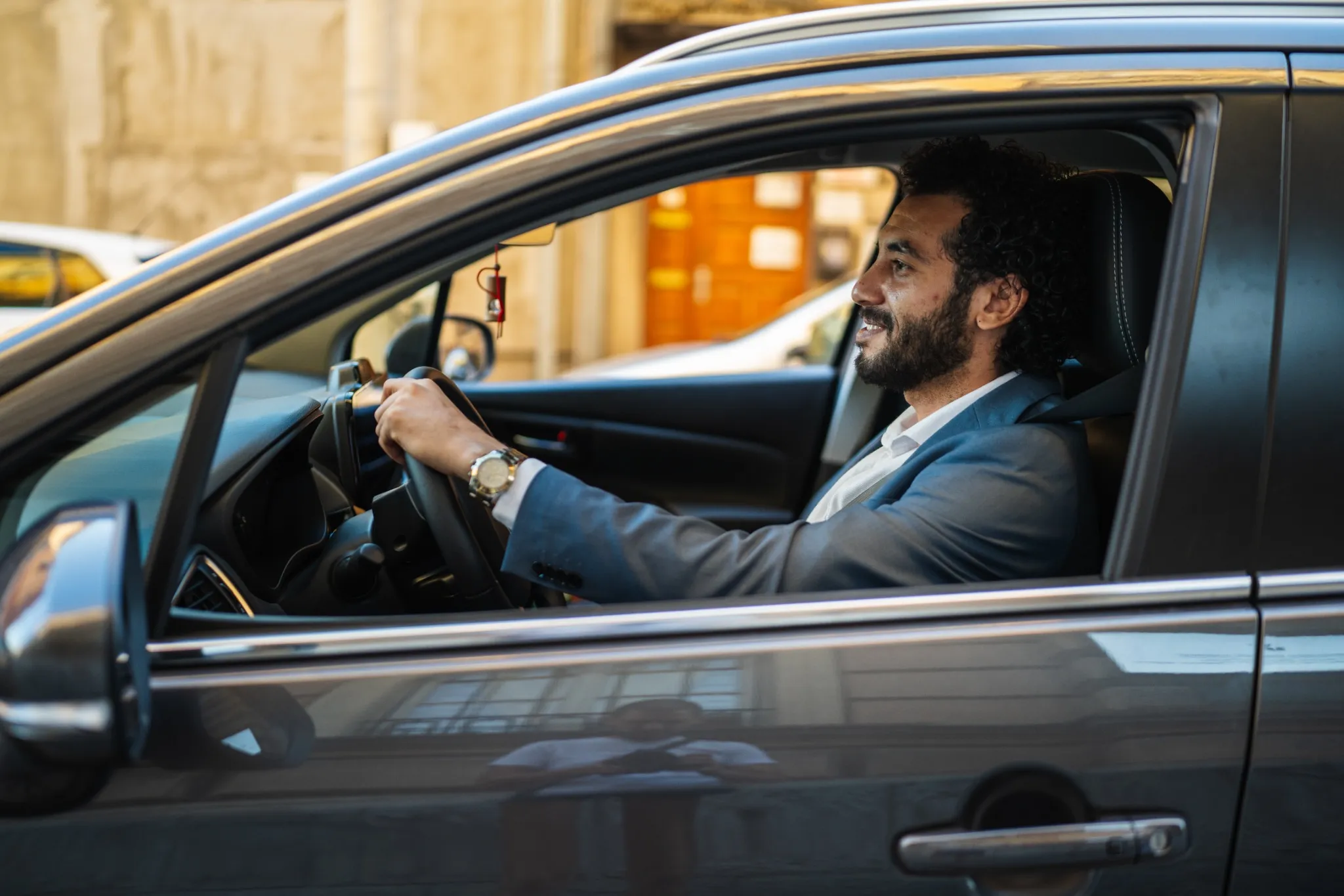 Man in suit driving car