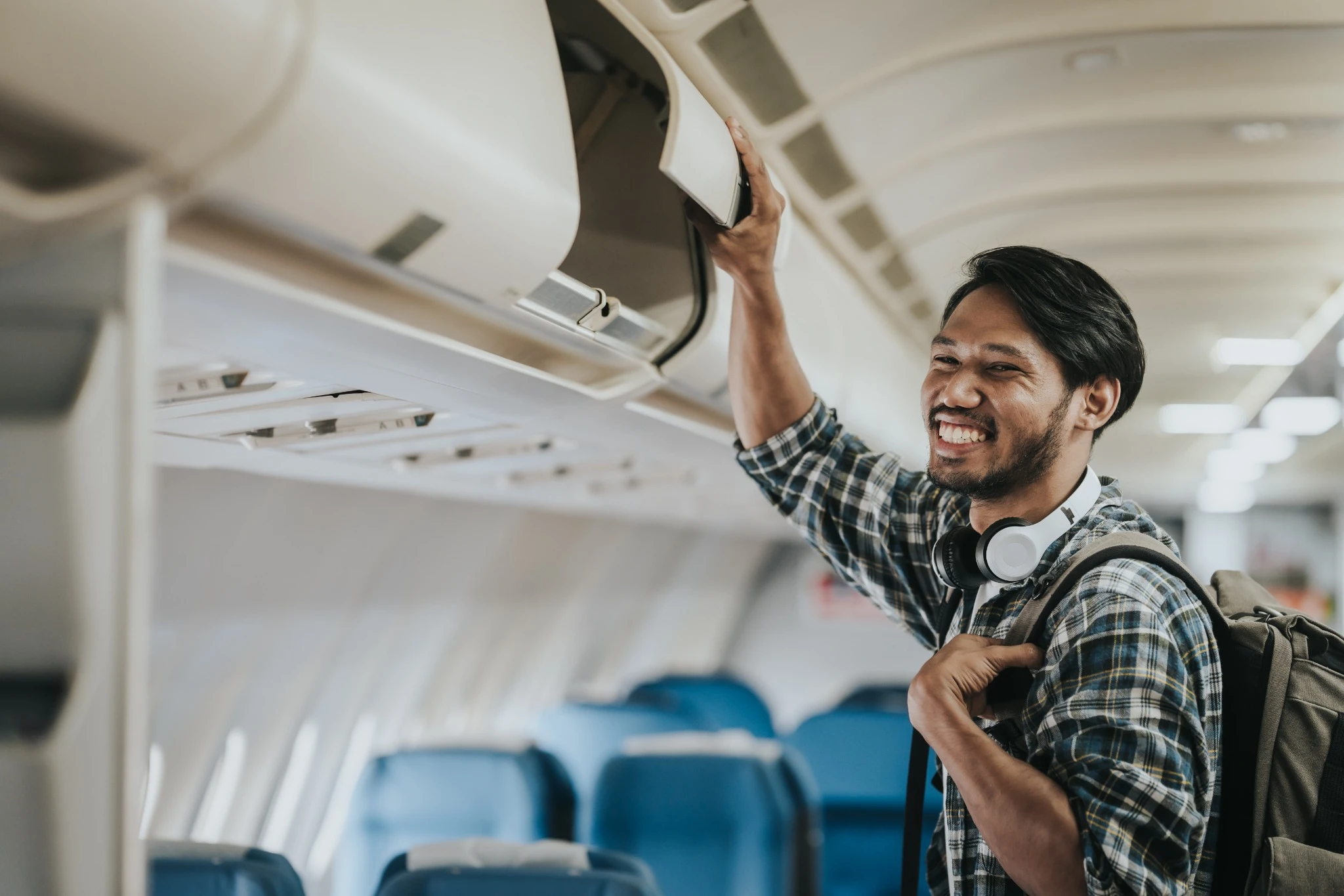 Asian male tourist enjoying airplane travel, traveling around the world on his own