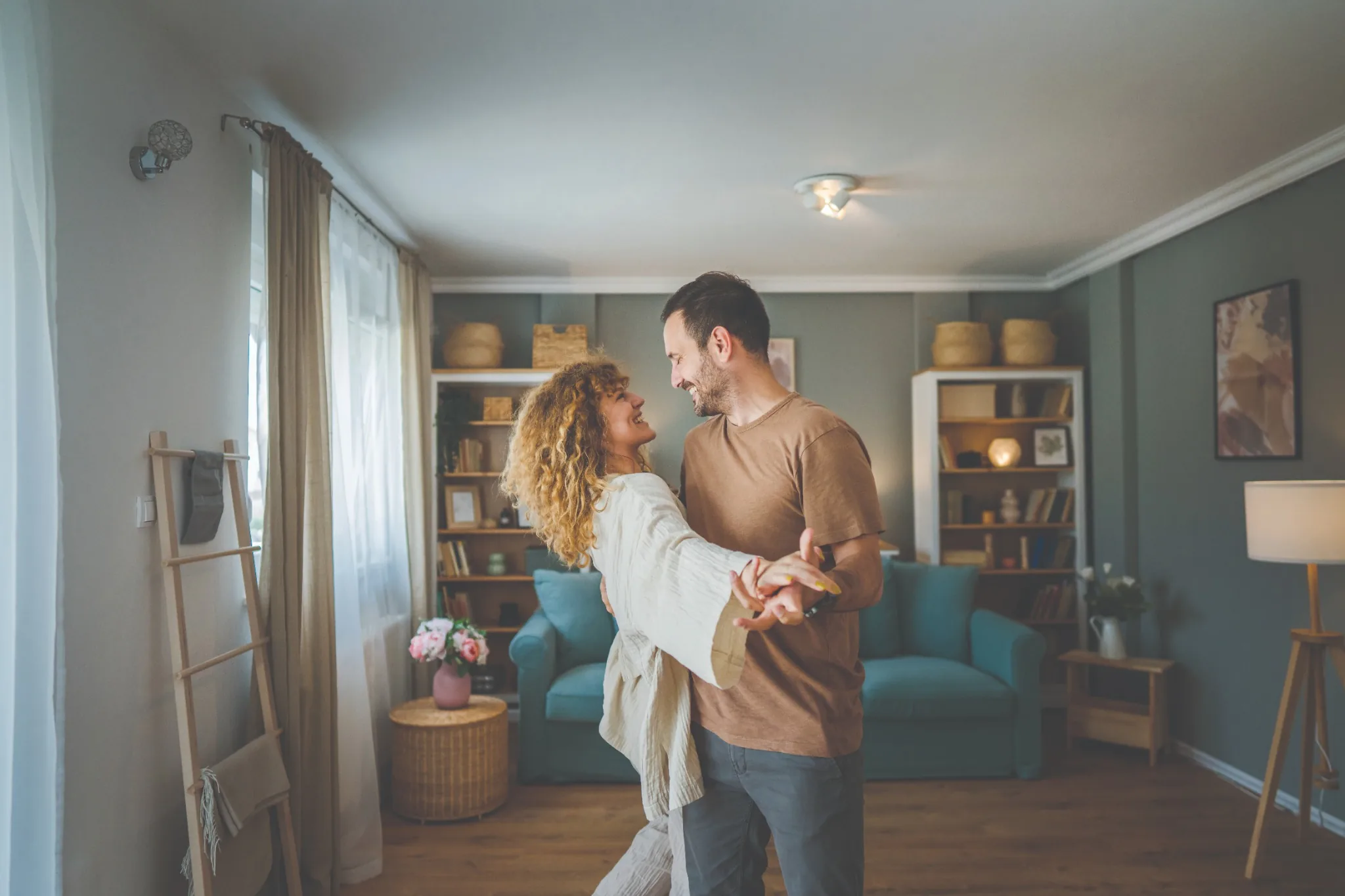 couple slow dancing and smiling at each other in living room