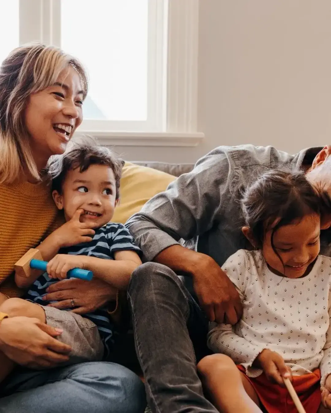 parents with two young kids playing on the floor