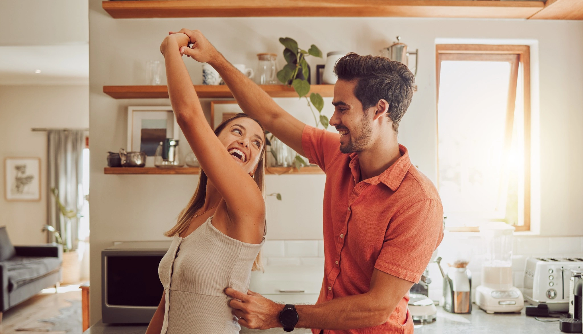 Young couple dancing in the kitchen at home