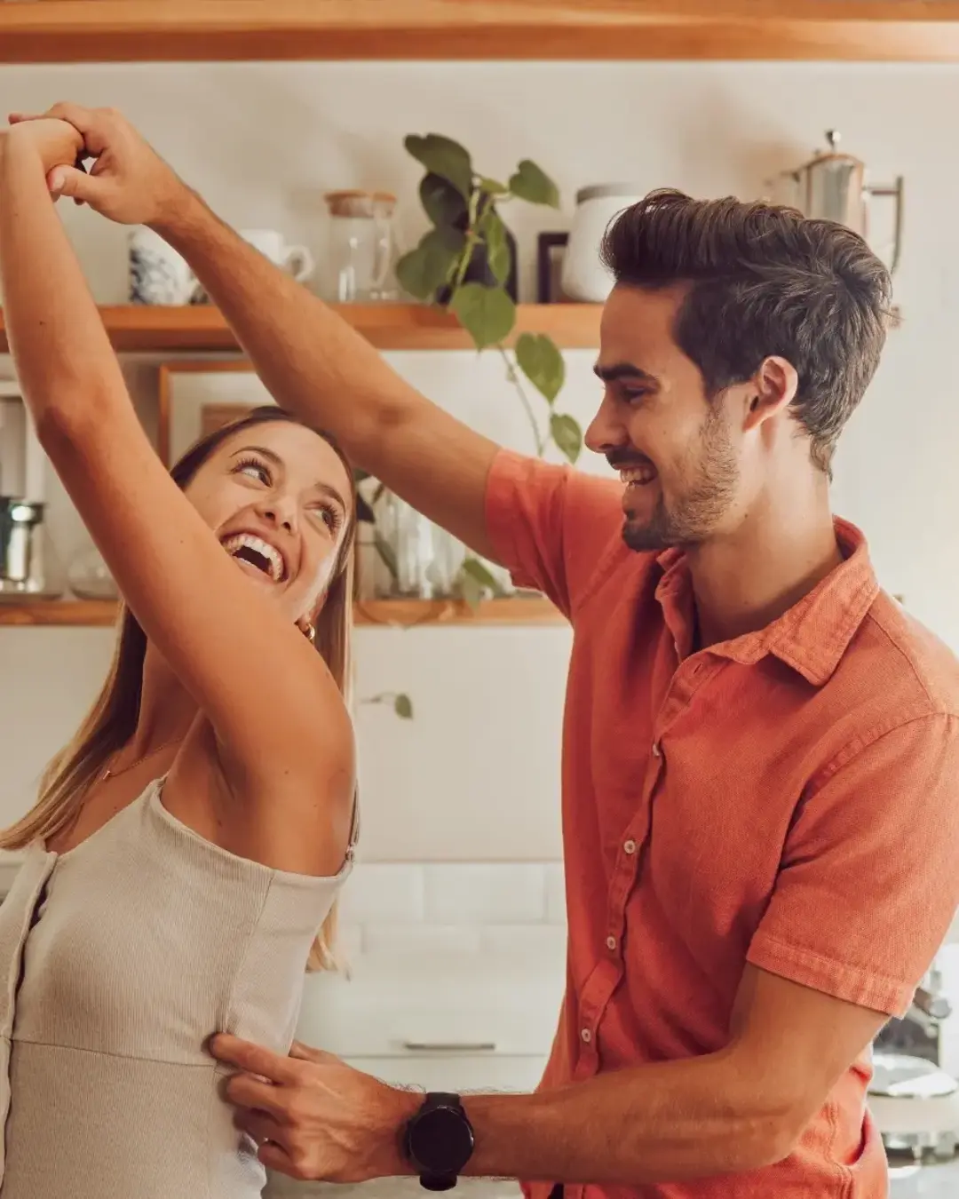 Young couple dancing in the kitchen at home