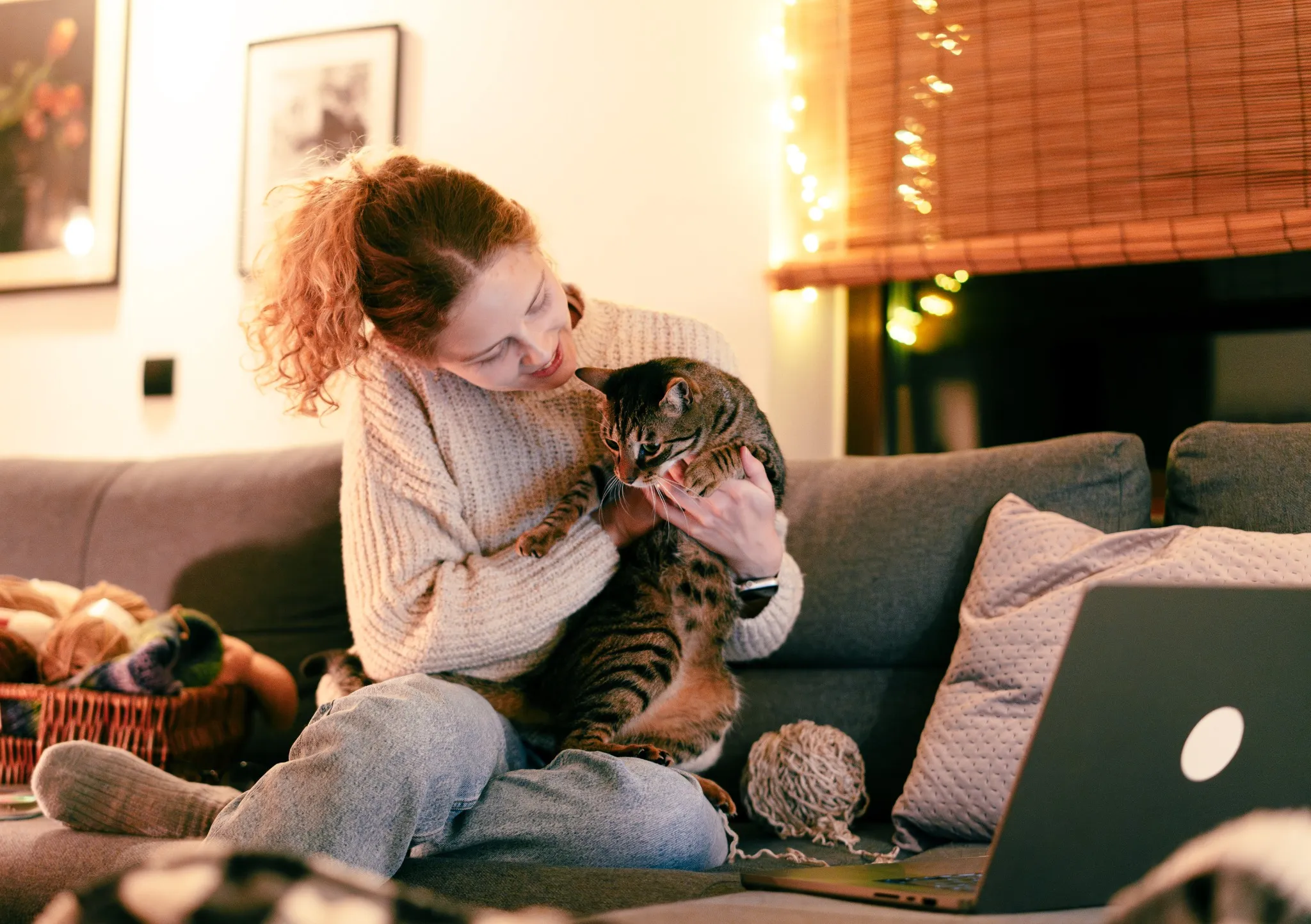 girl on couch with her cat and laptop