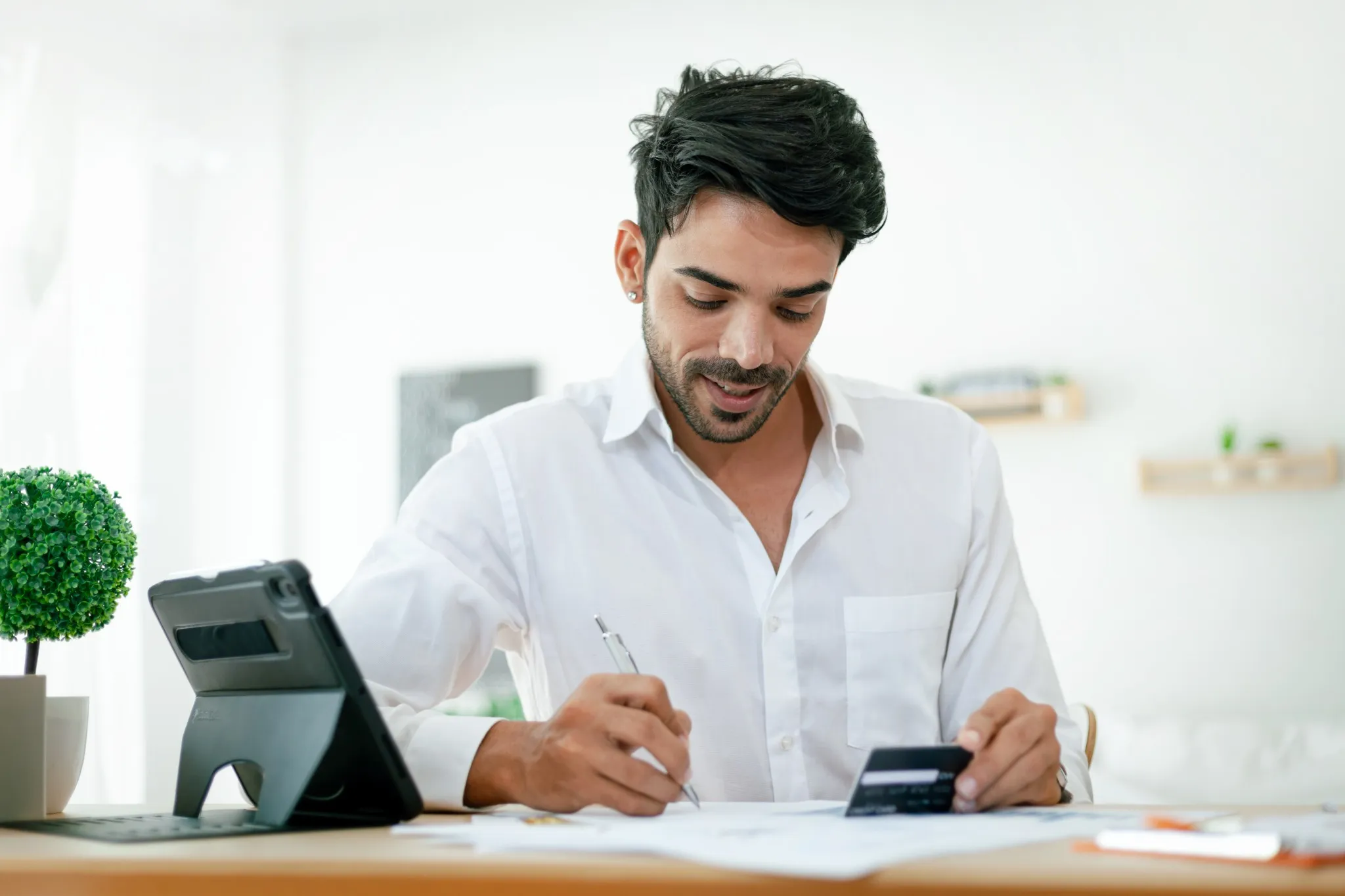 Handsome businessman in a white dress Happy working at home. Working at home. Handsome young man in work clothes. Happy working
