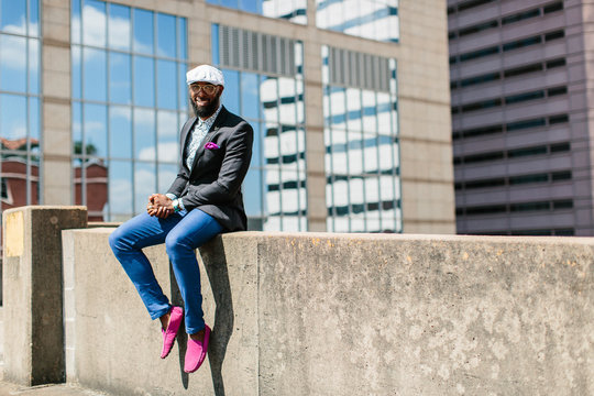 Man sitting on the edge of a roof in the sun