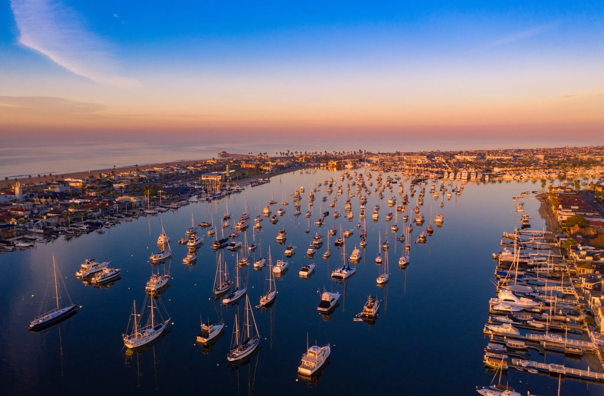 Drone shot of Newport Beach harbor in Orange County, California early in the morning with boats below.