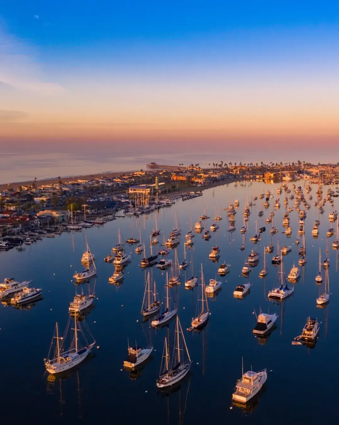 Drone shot of Newport Beach harbor in Orange County, California early in the morning with boats below.