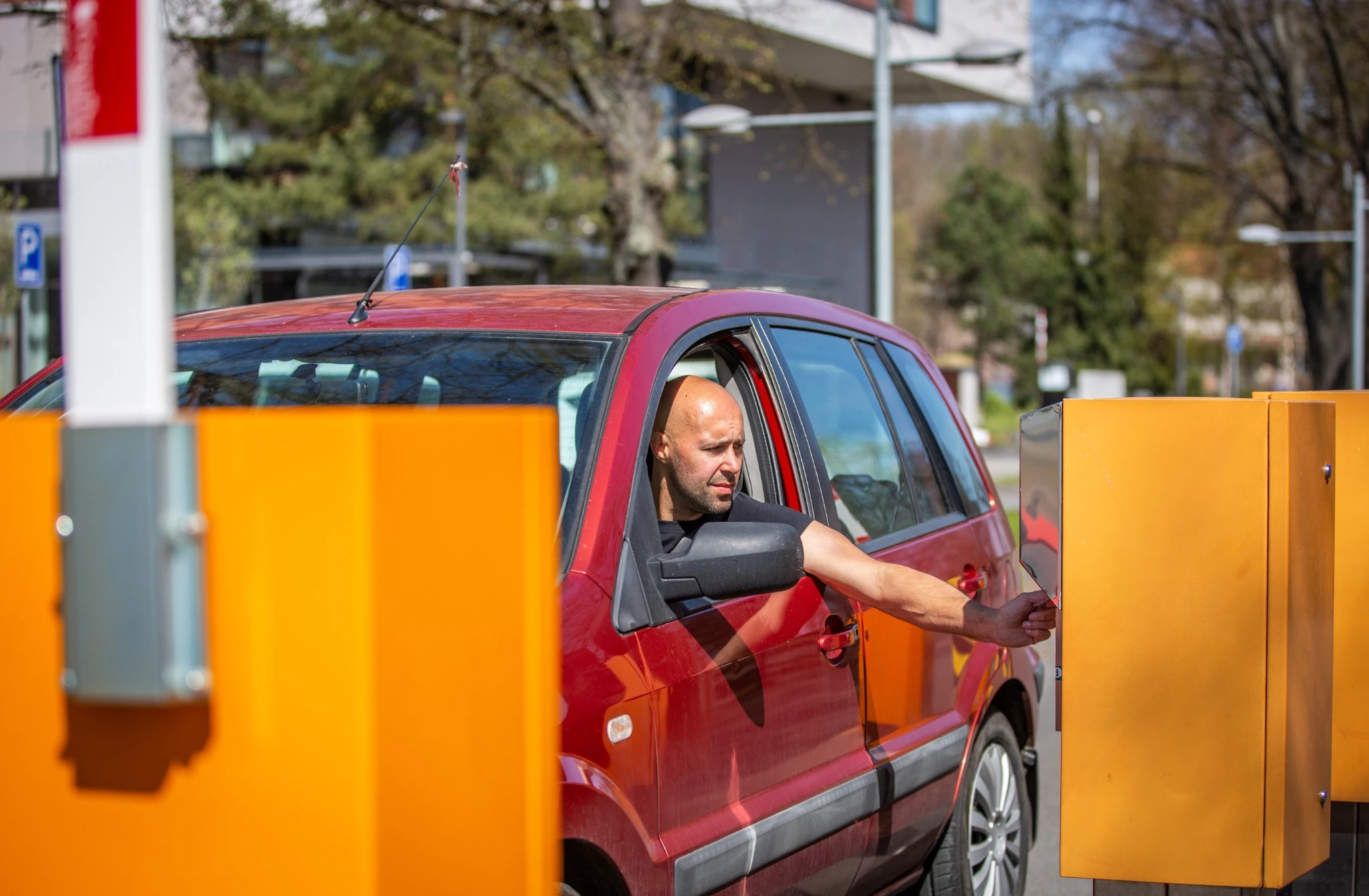 A driver of the car paying parking by a credit card, payment process.