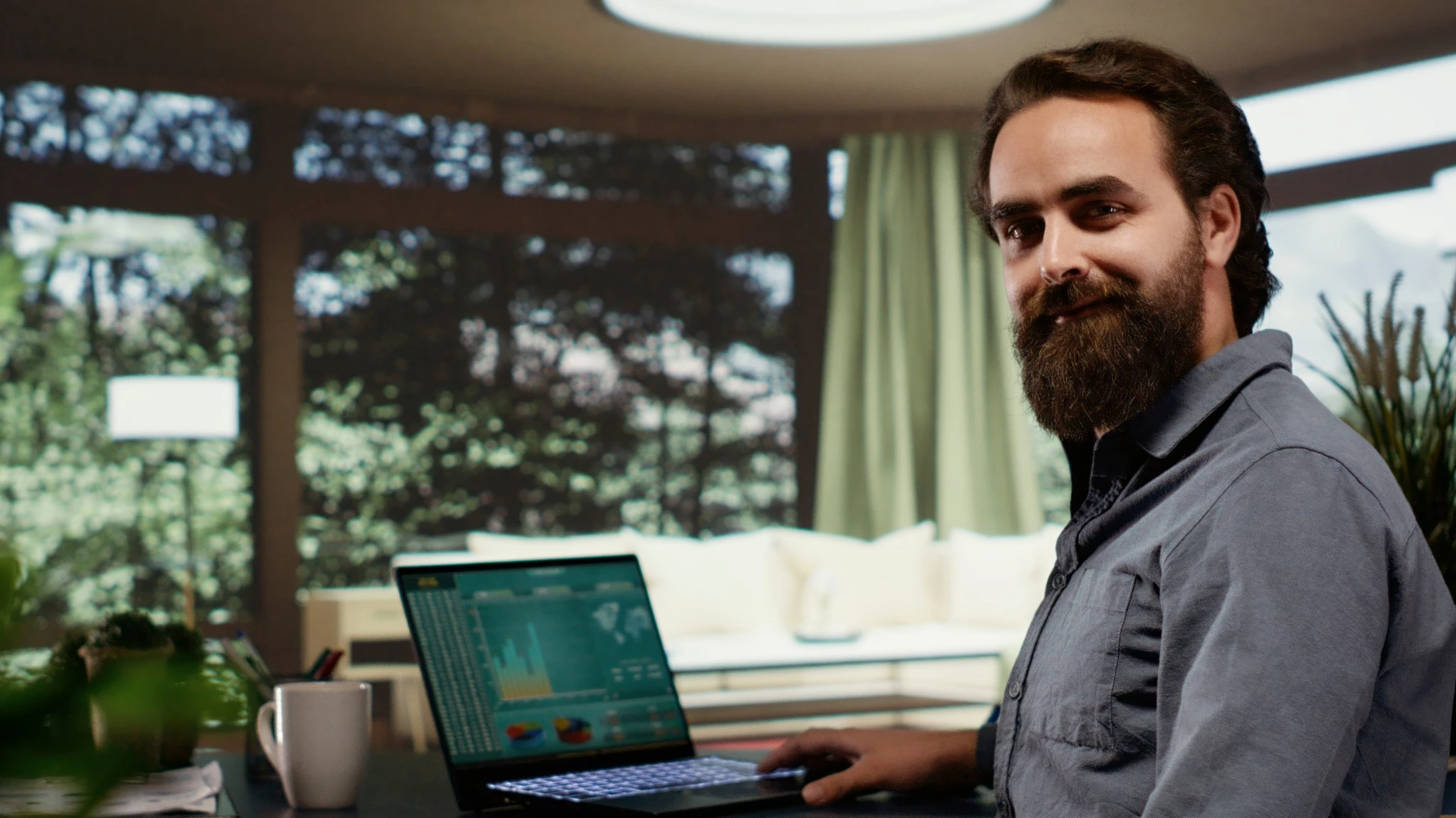 Man with beard working on laptop at home