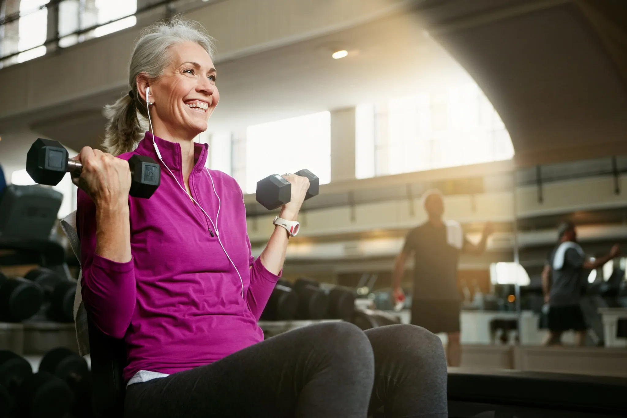 Live, laugh, love, lift. Portrait of a happy senior woman working out with weights at the gym..