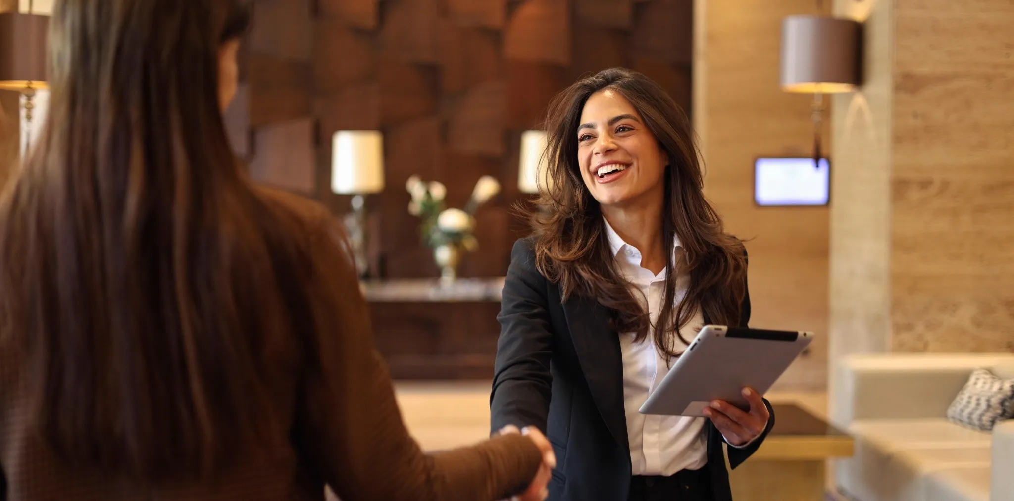 Friendly hospitality worker shaking hands with a guest