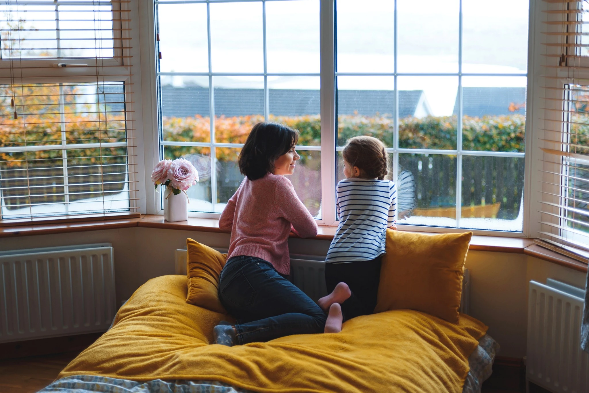 mother and daughter talking at window.