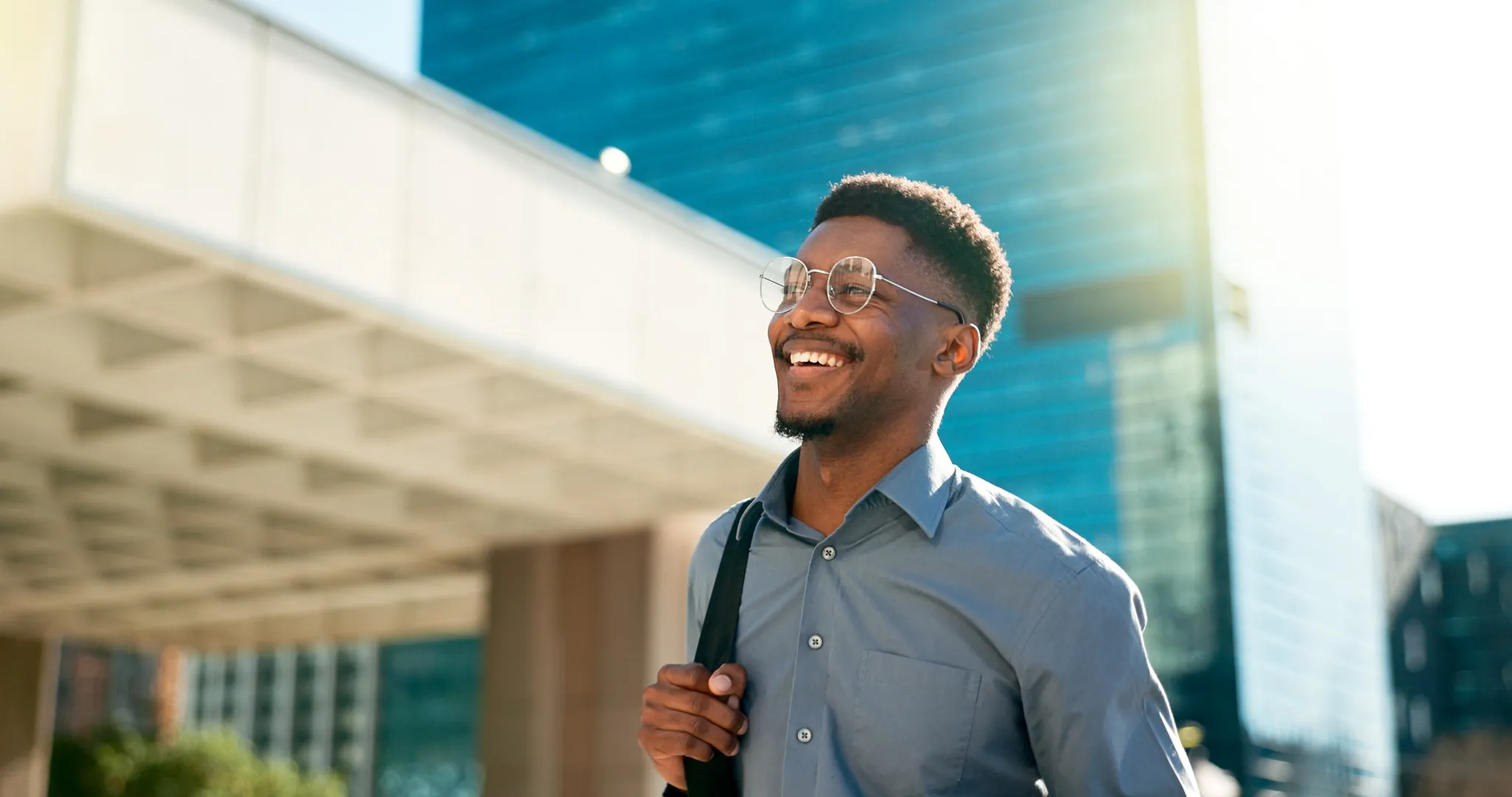 Smiling business man with backpack outside