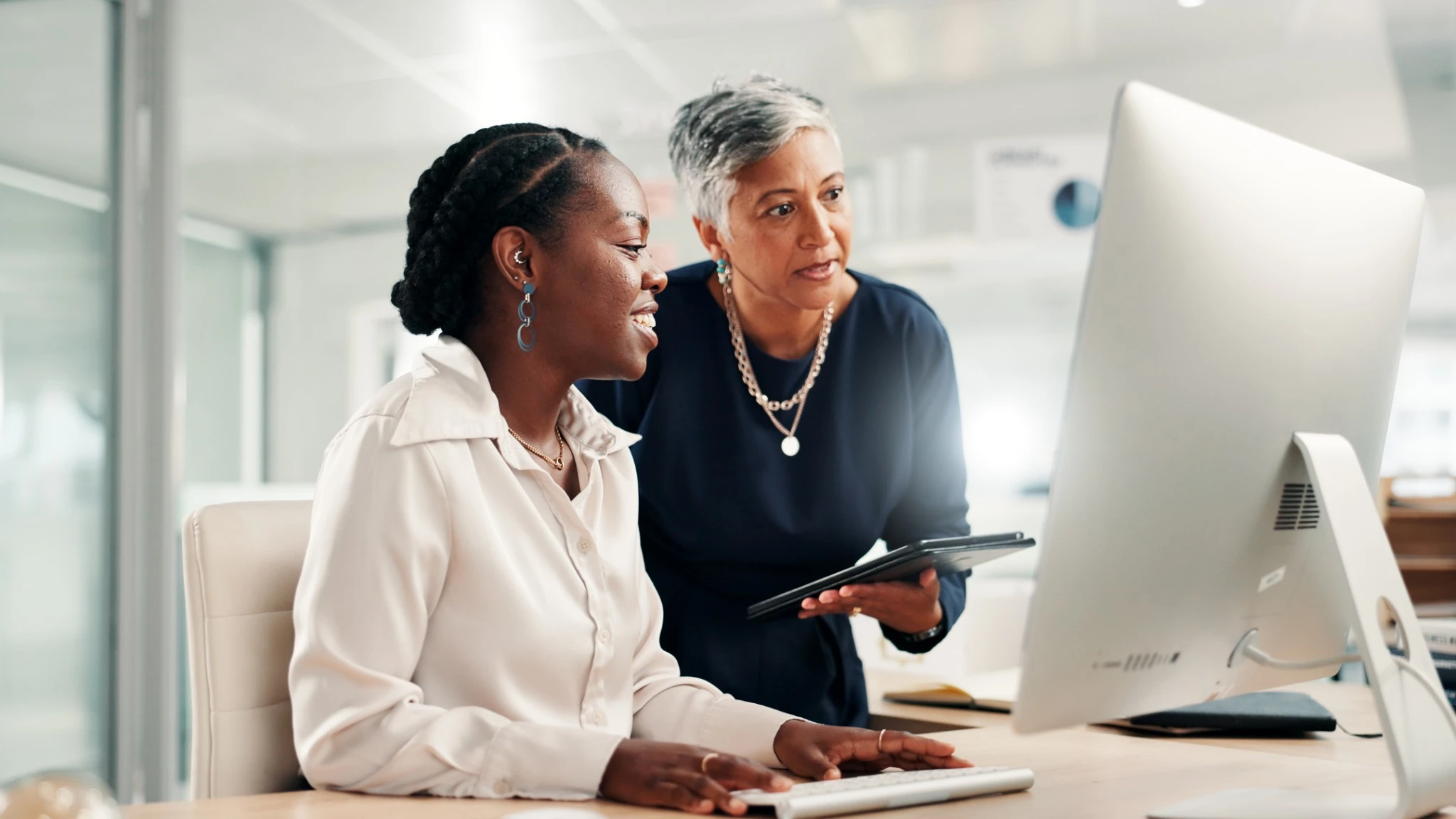 Older woman looking over her mentee's work