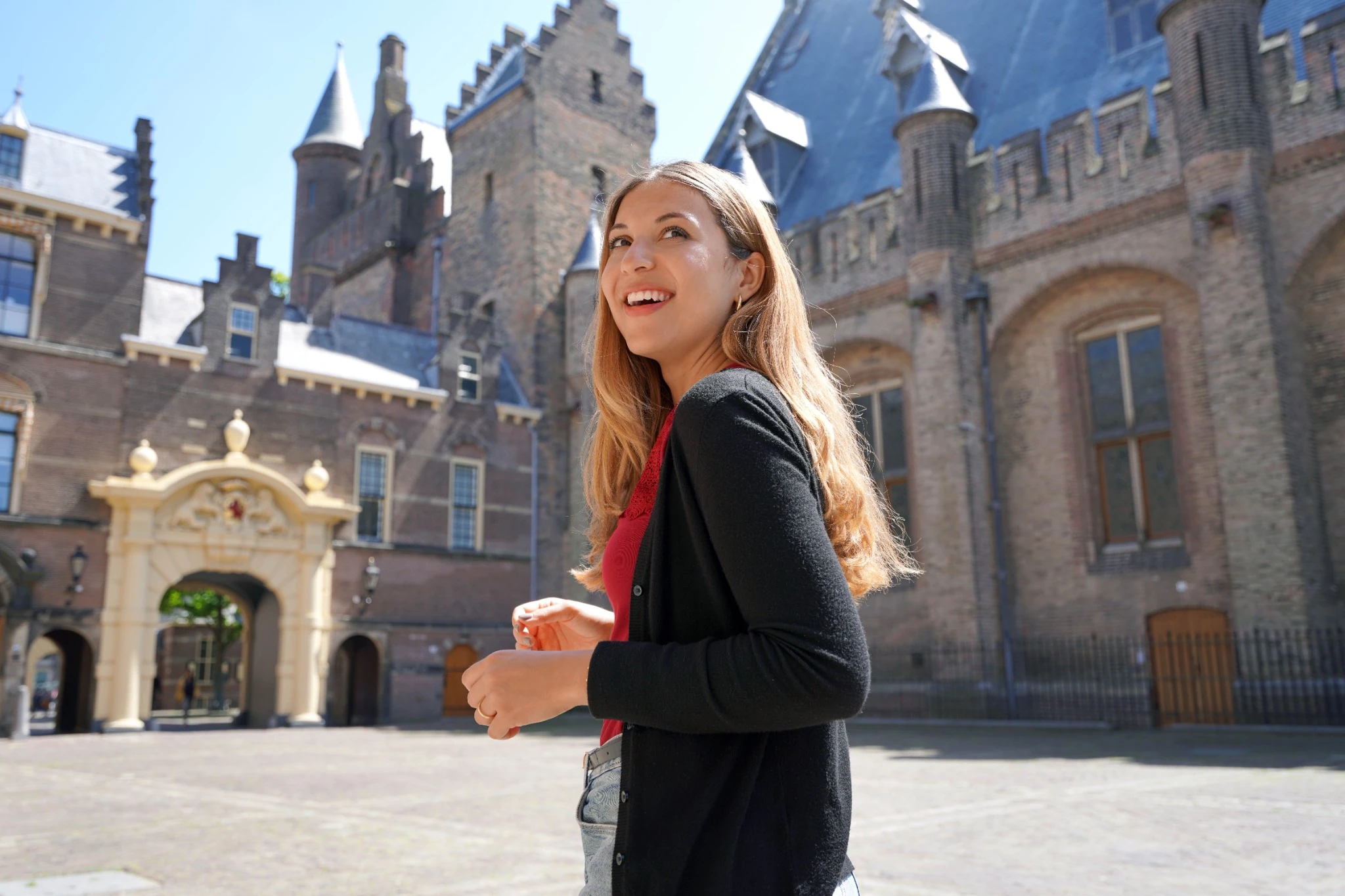 Young student girl visiting the complex of buildings of Binnenhof in The Hague, Netherlands.