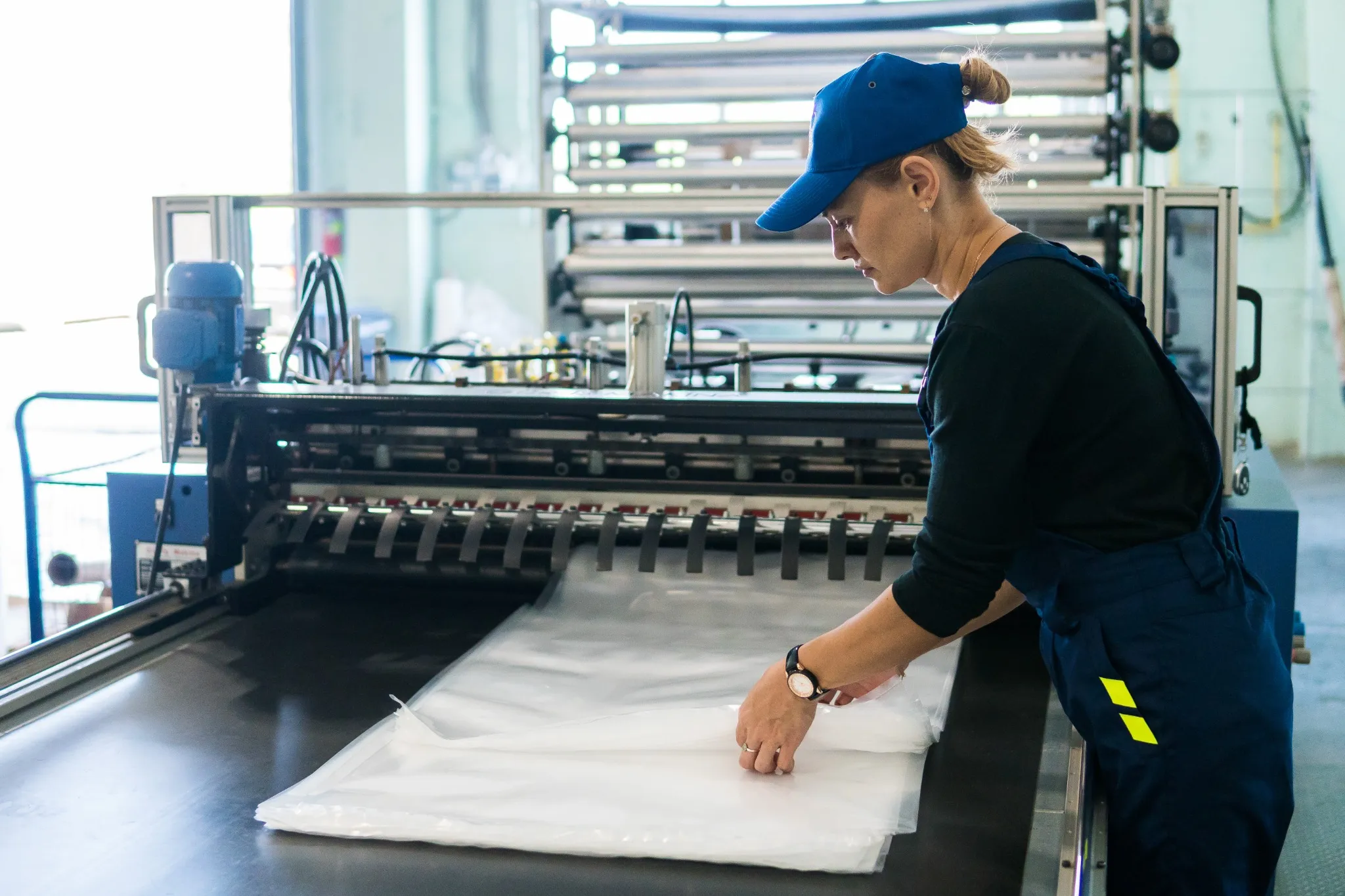 woman worker in the production of plastic packaging folds finished products.