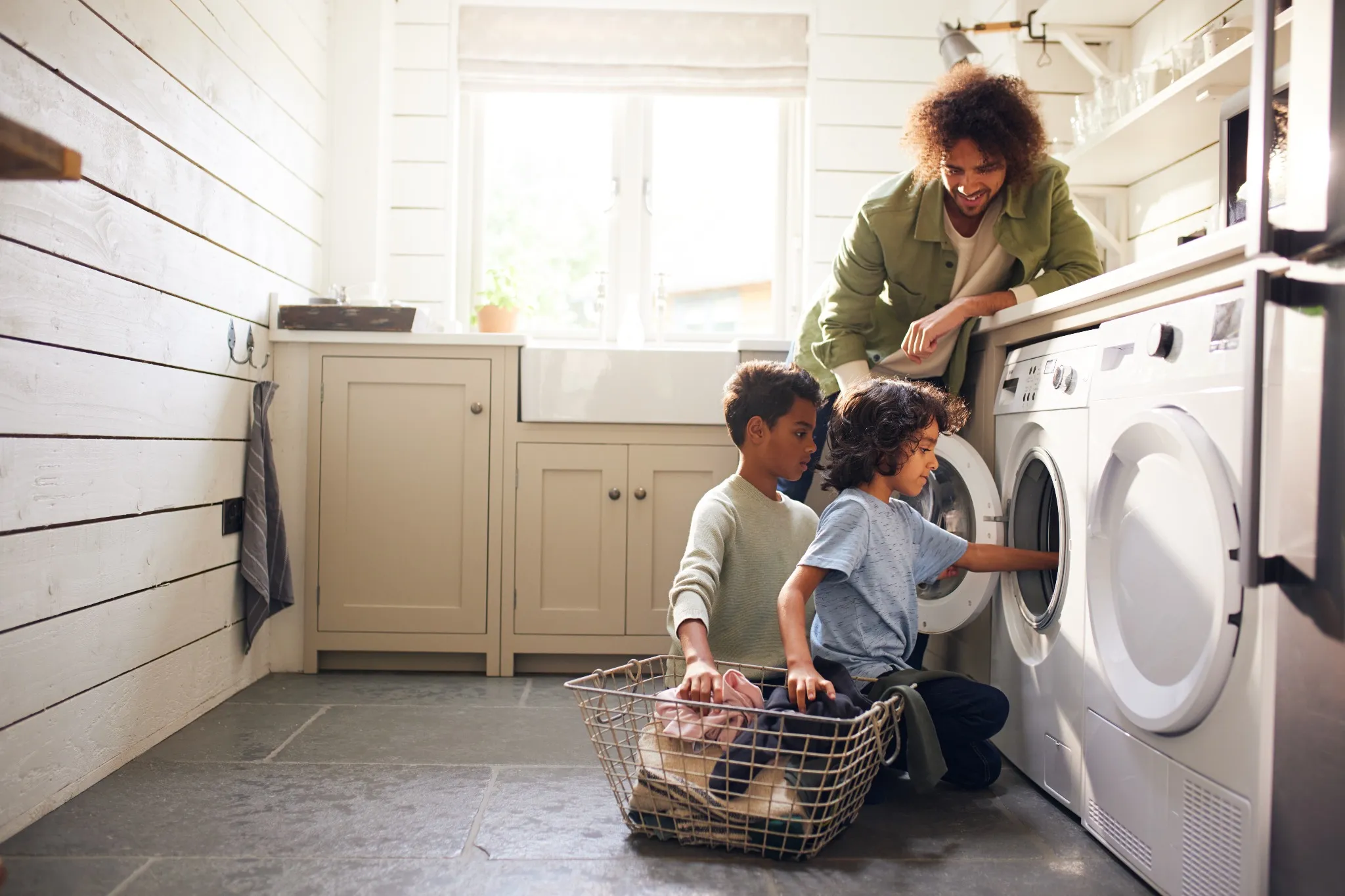 Man doing laundry with his kids 
