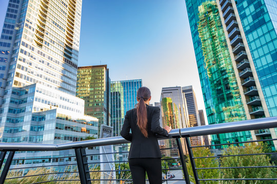 Business woman looking into the city center skyline