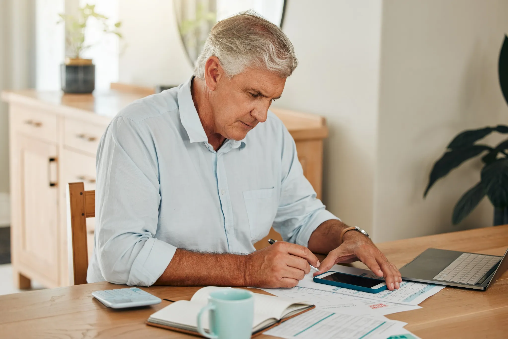 Man, elderly and phone for tax or budget banking with paper at home.