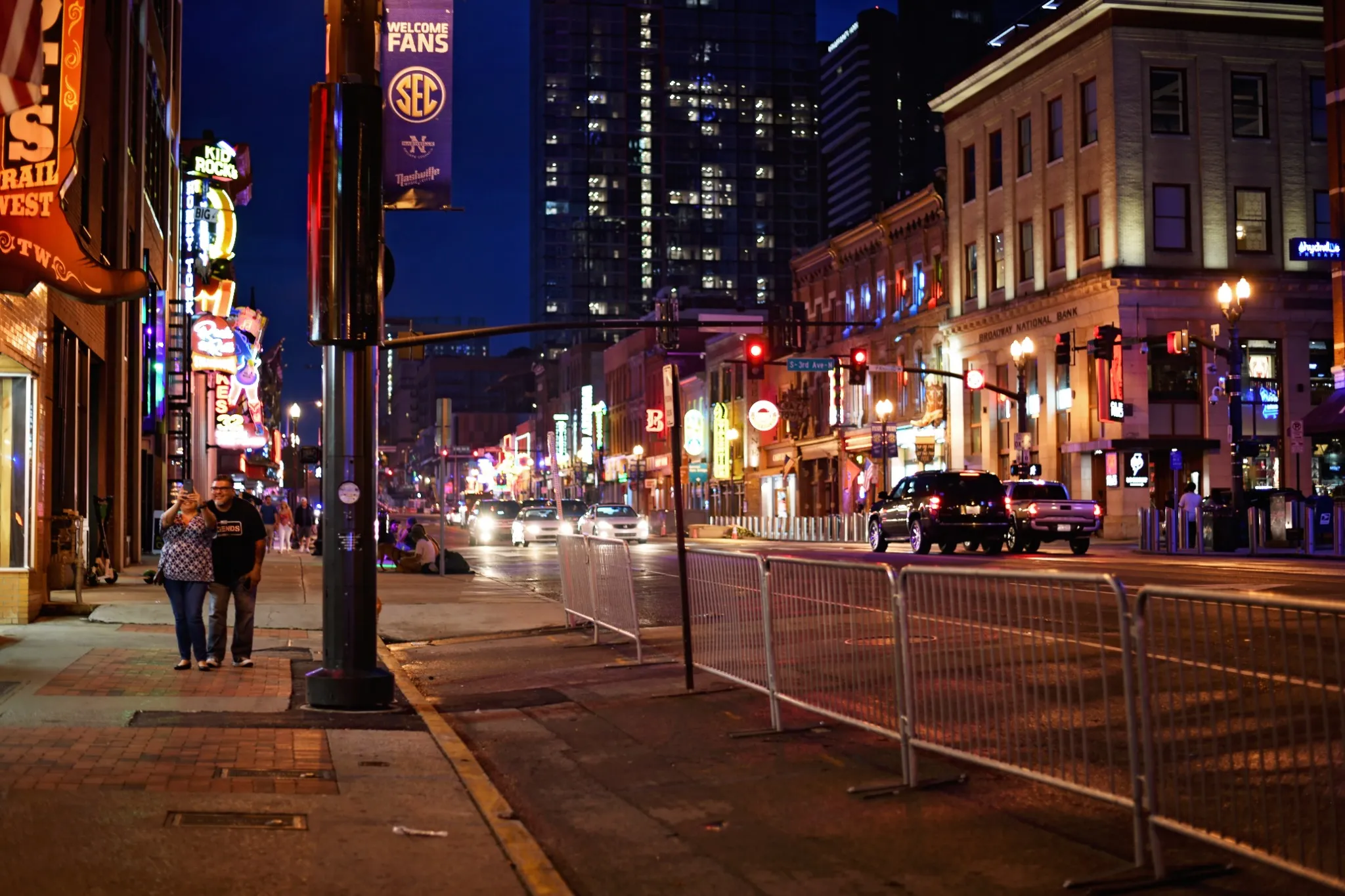 couple walking streets of downtown nashville at night