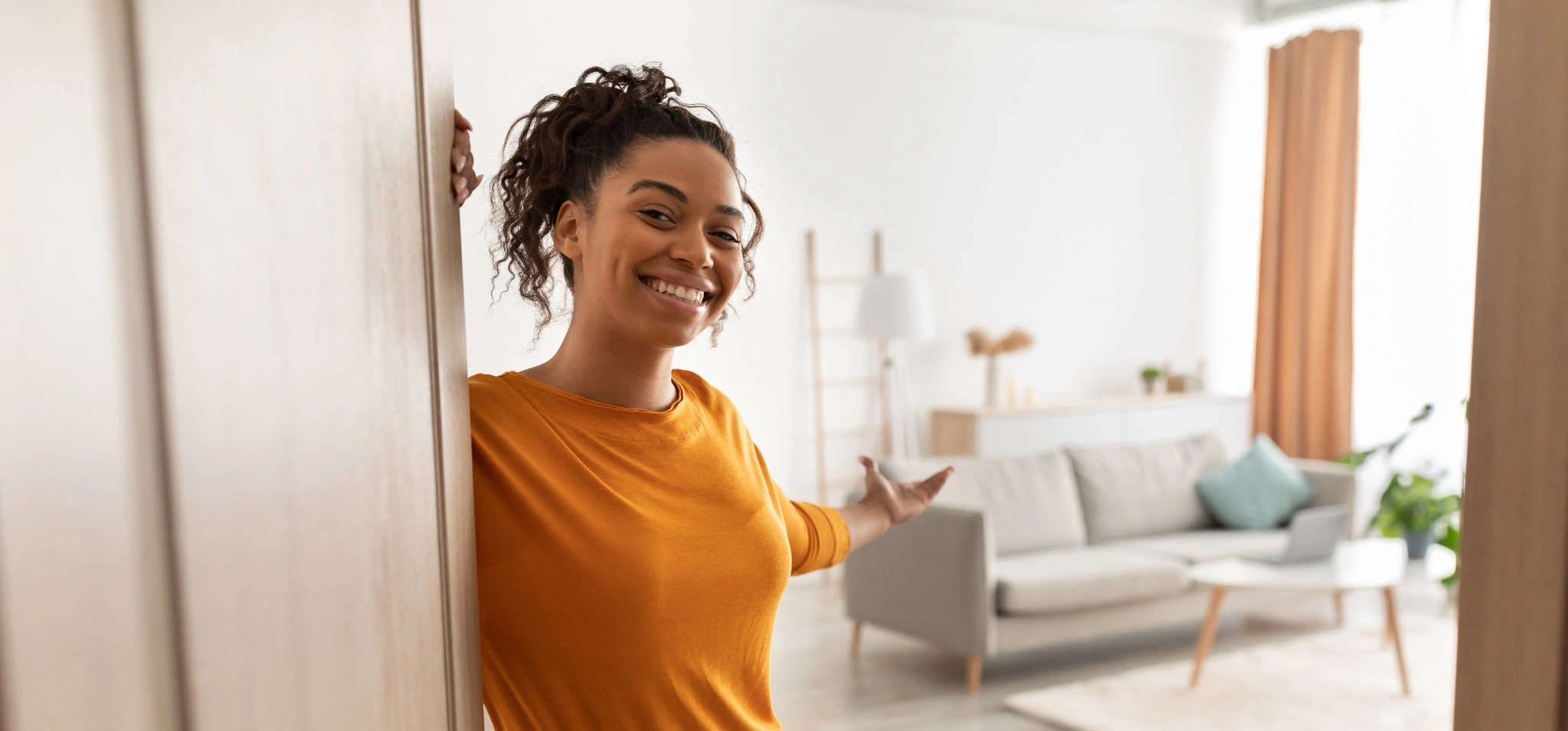 Friendly woman welcoming into apartment