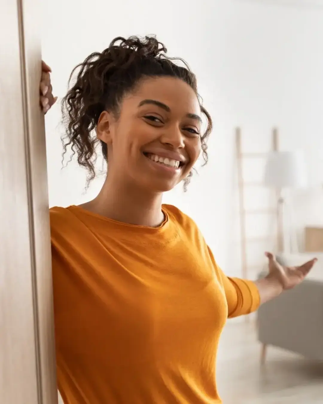 Friendly woman welcoming into apartment