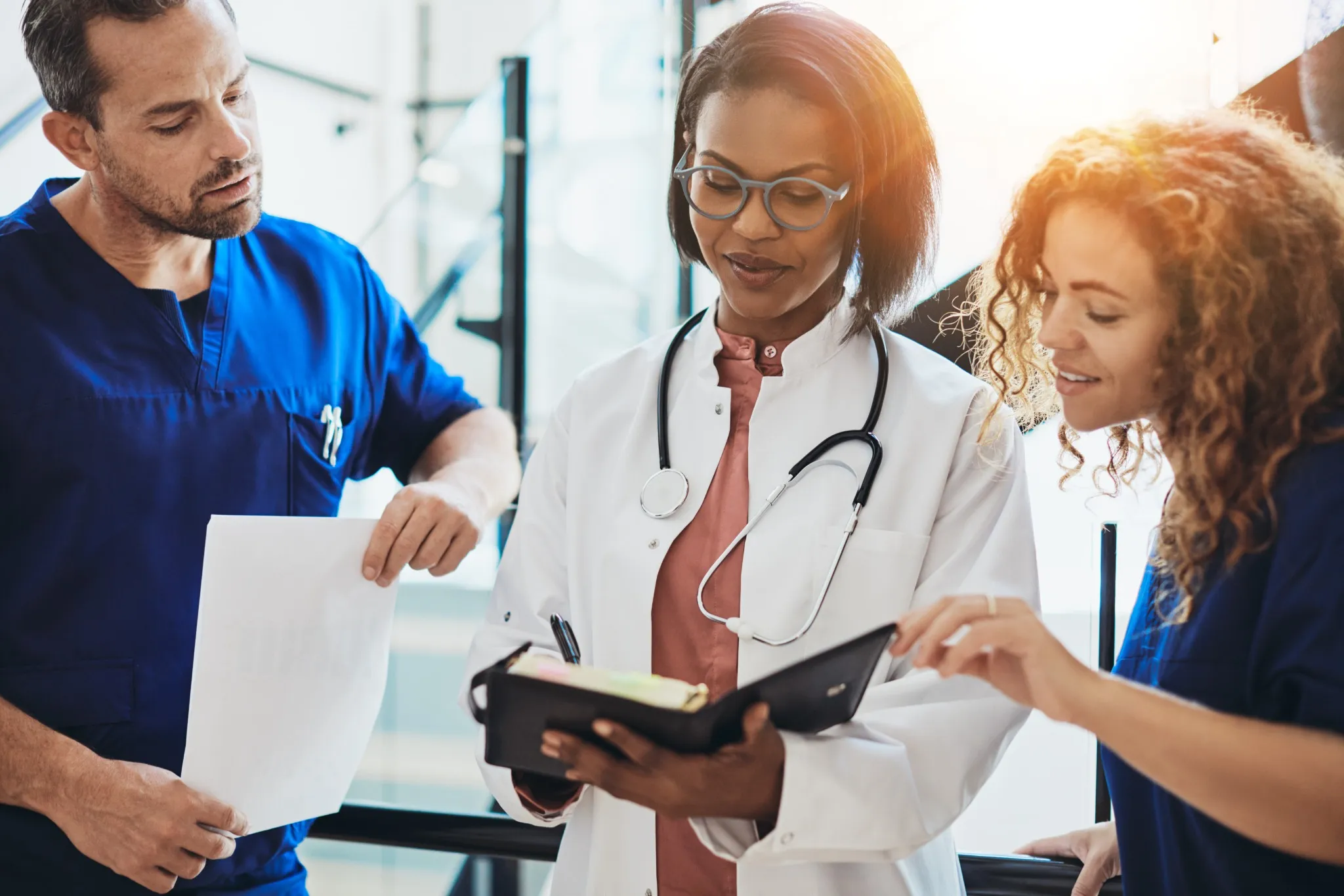 Diverse group of doctors talking together in a hospital corridor.