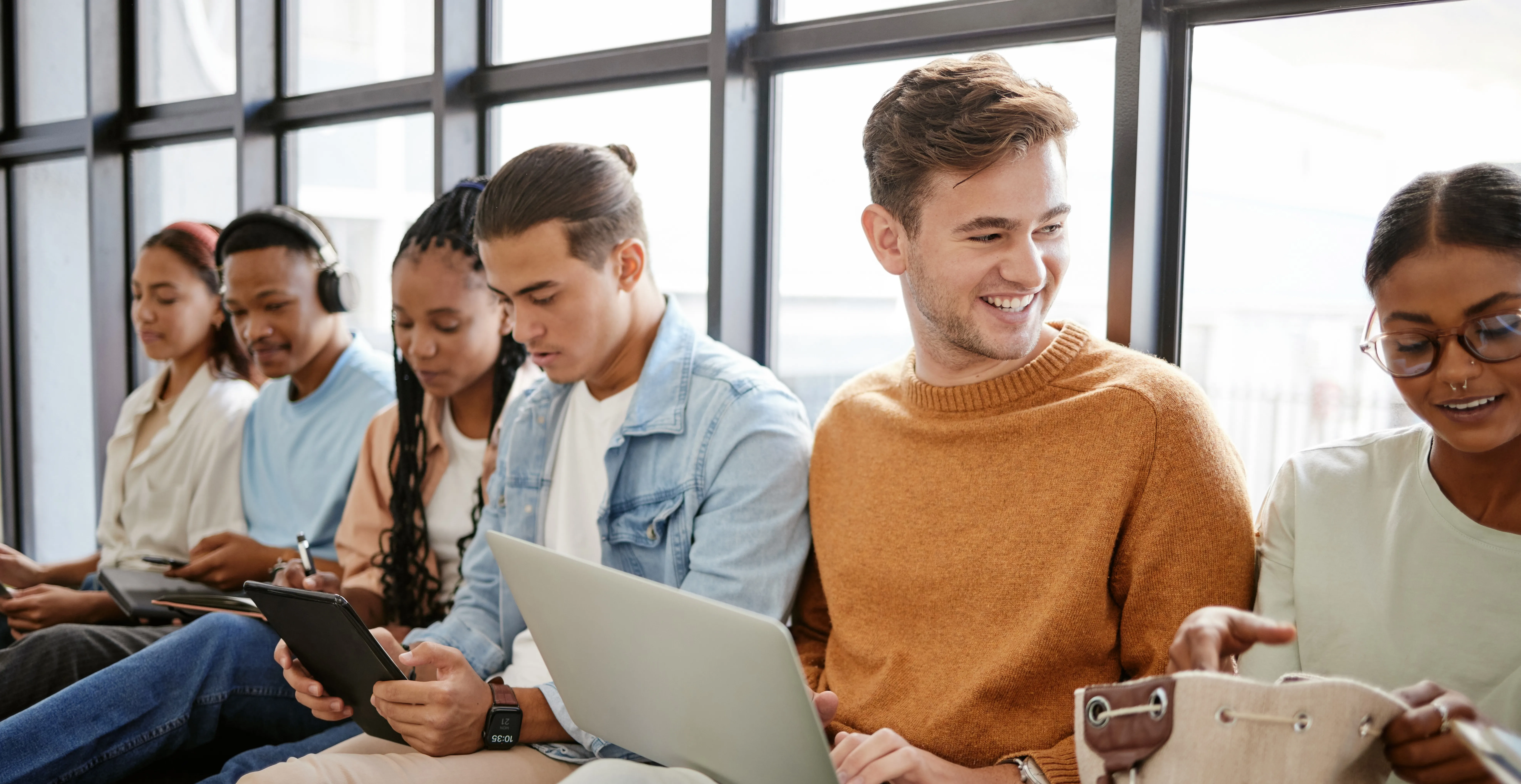 A group of interns interacting or working sitting in front of a window
