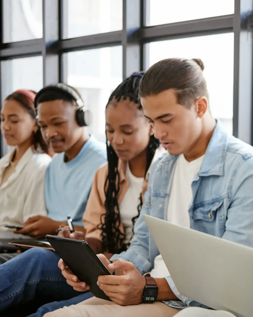 A group of interns interacting or working sitting in front of a window