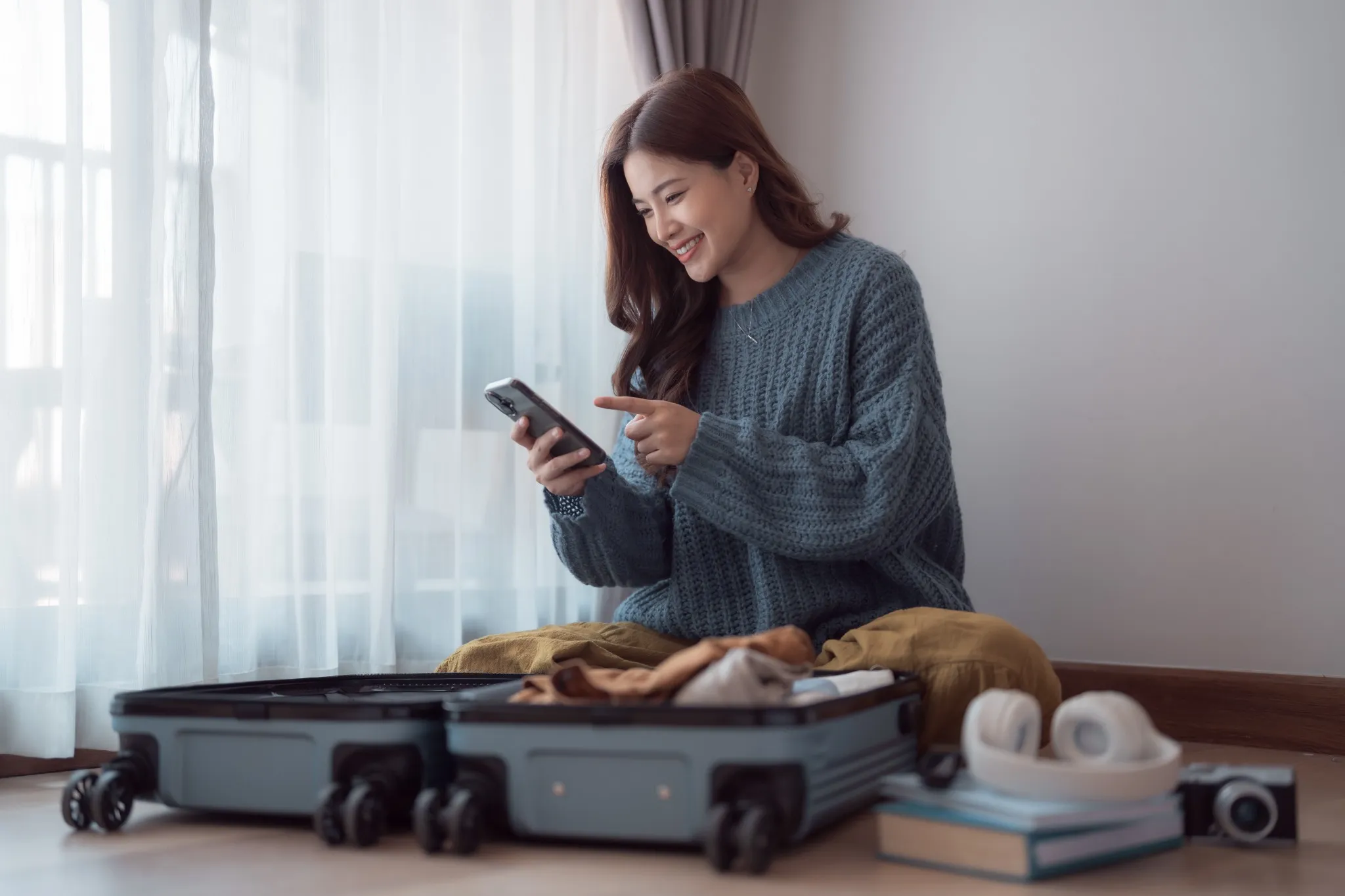 Woman opening suit case in hotel room