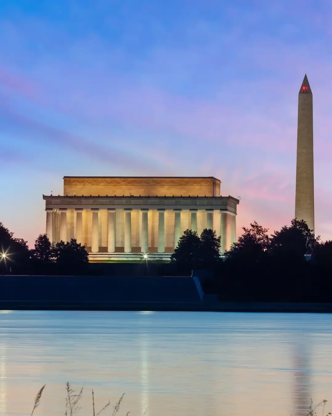 Lincoln memorial and Washington momument at dusk with purple sky in background.