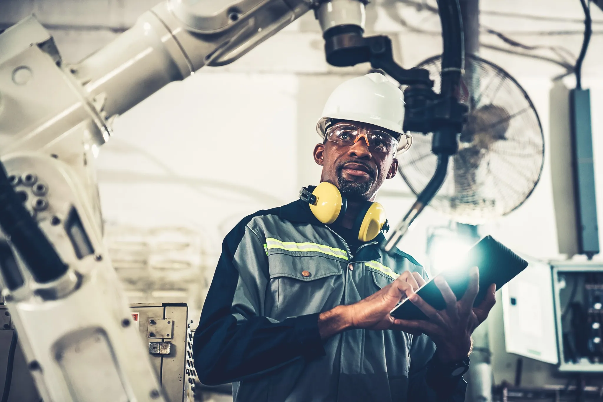 African American factory worker working with adept robotic arm in a workshop . Industry robot programming software for automated manufacturing technology 