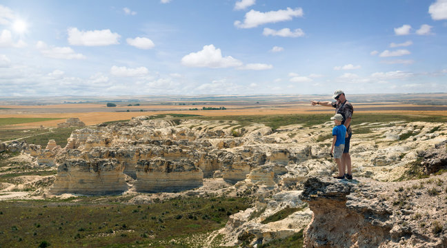 Father and son stand on the rock 