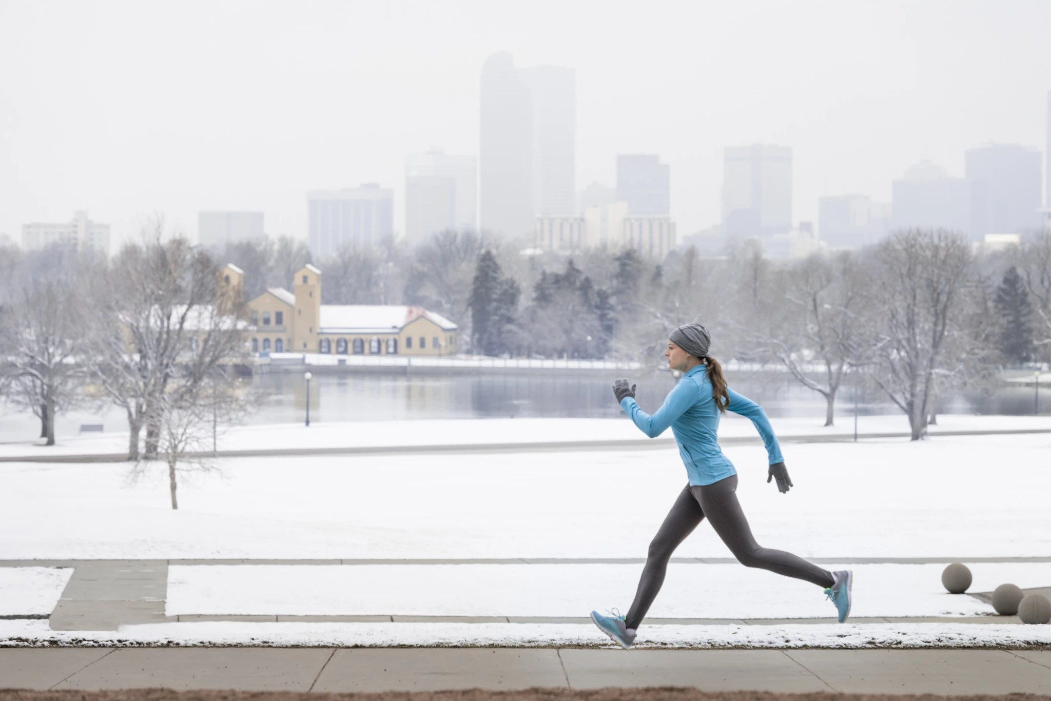 Woman running in the snow through Denver