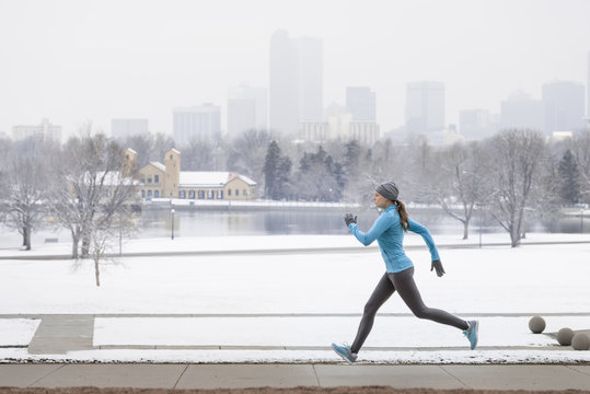 Woman running in the snow through Denver