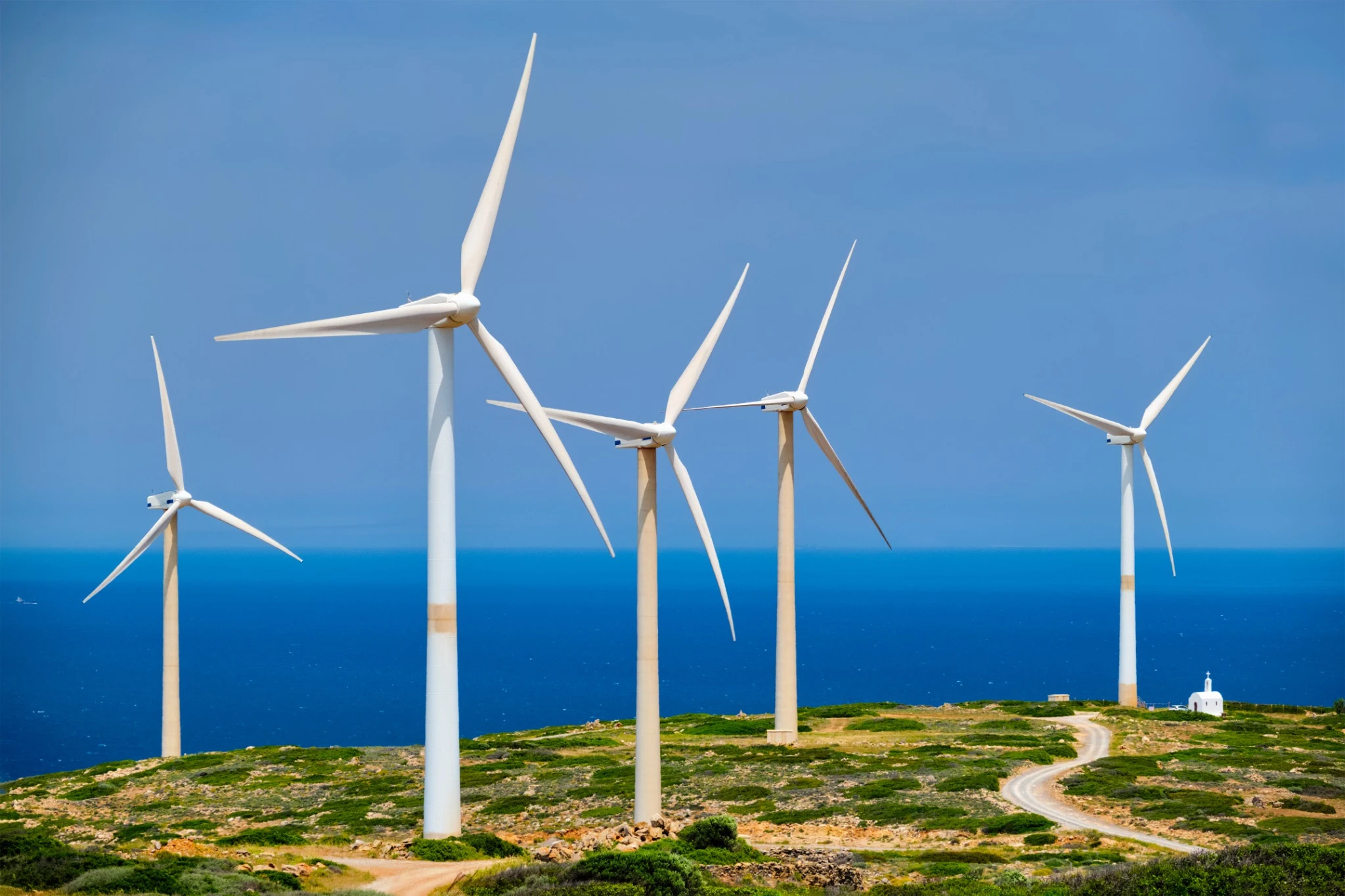 Wind farm on Crete island, Greece with small white church