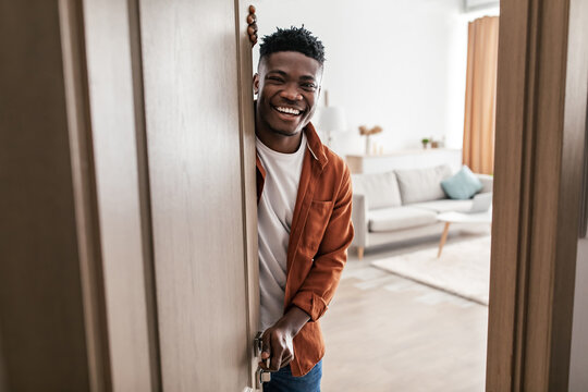Smiling black man opening door to his apartment