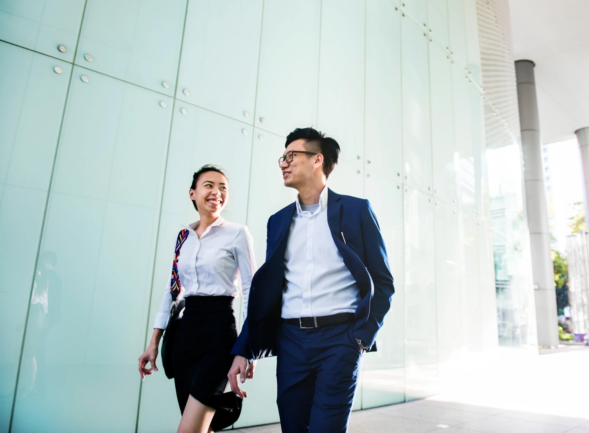 Asian couple in business attire walking 