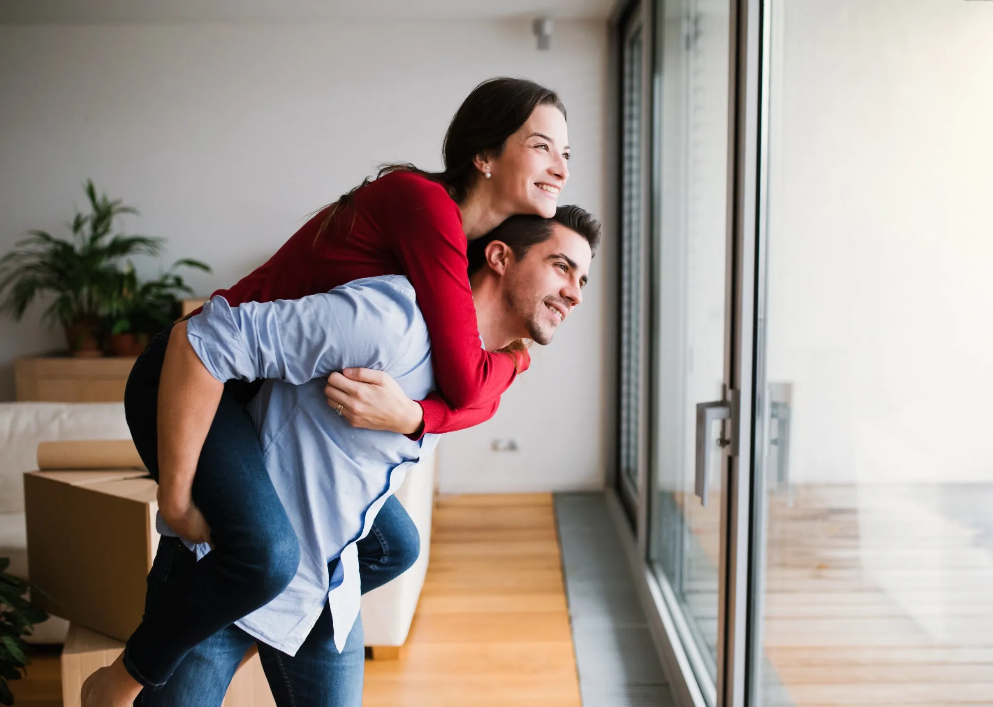 Couple looking out big window in apartment