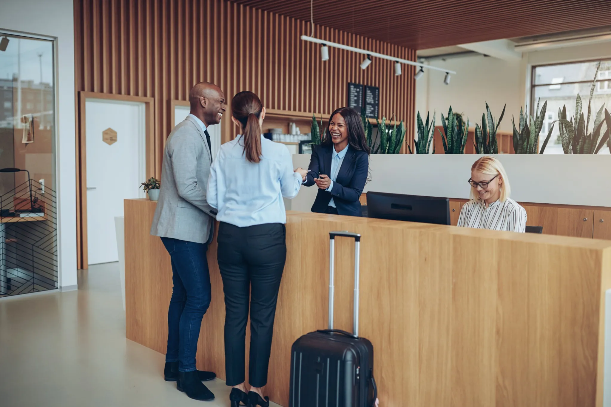 Two business travelers checking in at a hotel desk