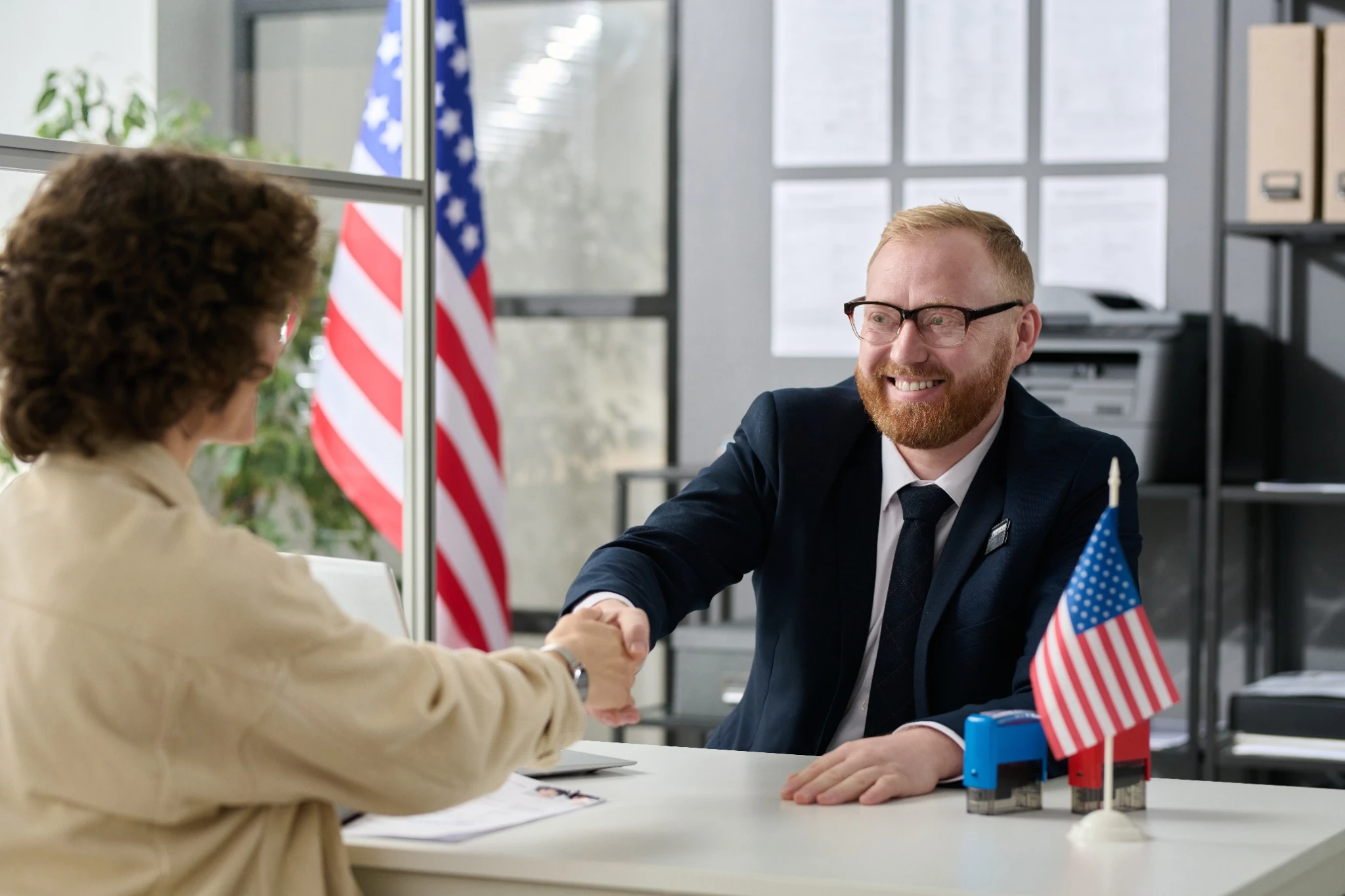 U.S. Government employee smiling and shaking hands with woman