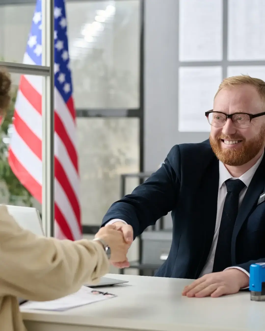 U.S. Government employee smiling and shaking hands with woman