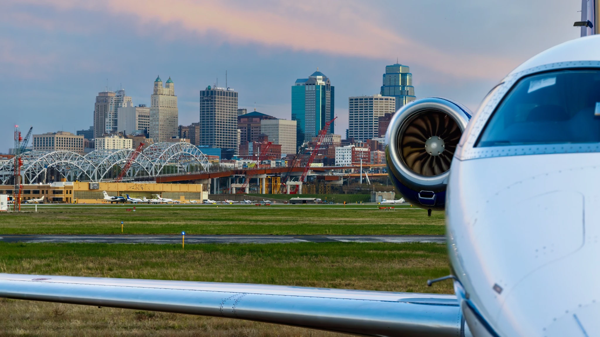 Kansas City at dusk with a private jet in the foreground.