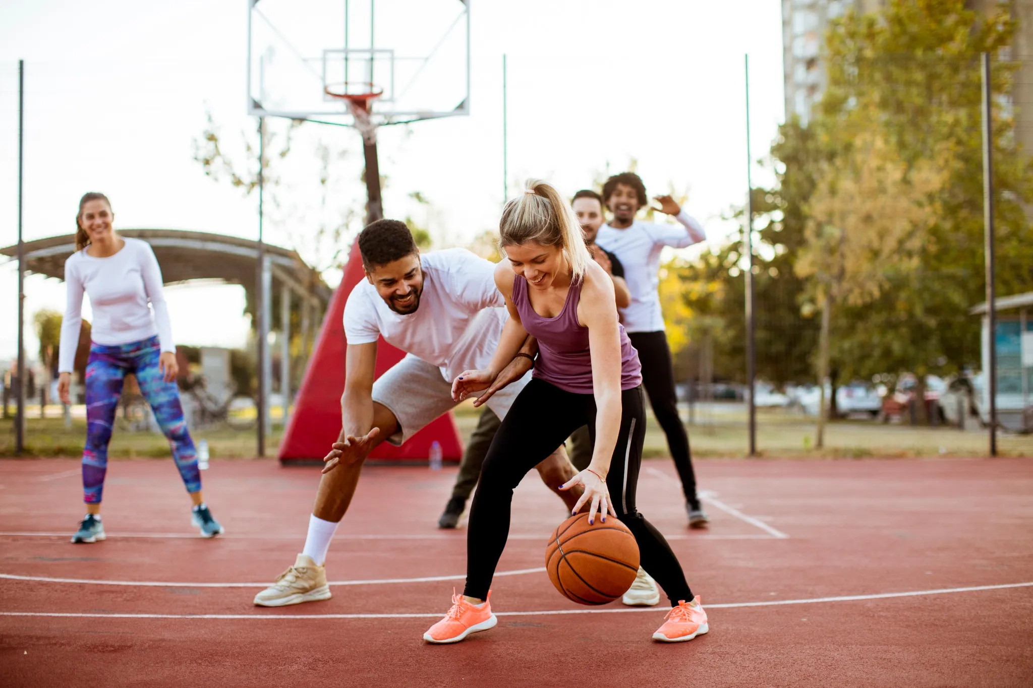 Young people playing basketball outside