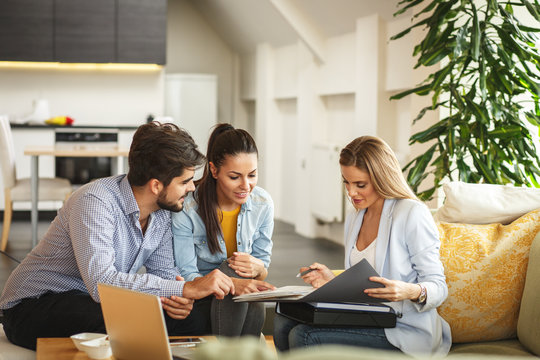 Couple looking at and discussing documents with agent