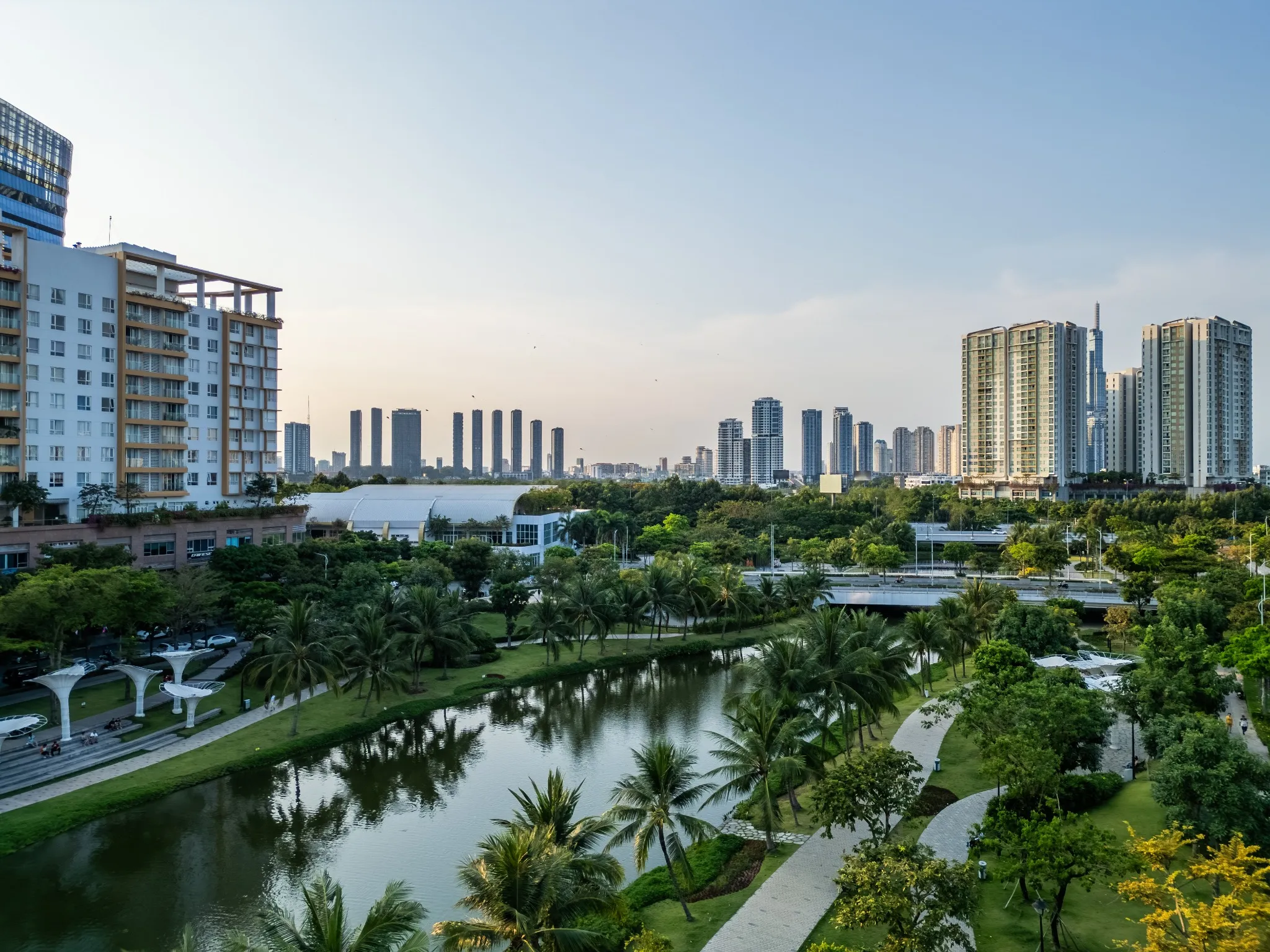 modern green urban park with green lawns and palm trees in downtown of big city with skyscrapers and contemporary architecture, sala luxury residential district, Ho Chi Minh