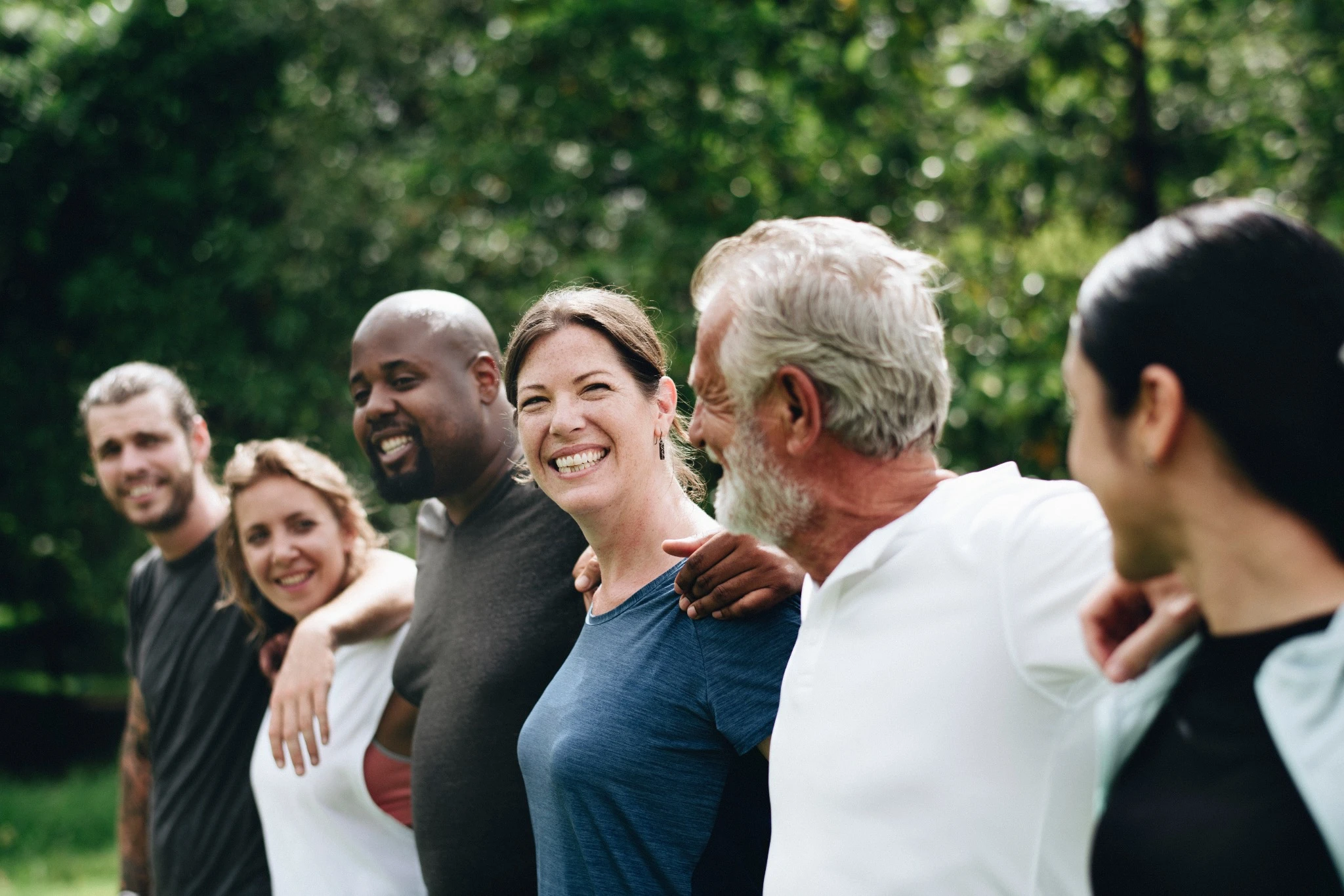 Diverse team happy with arms around each other's shoulders