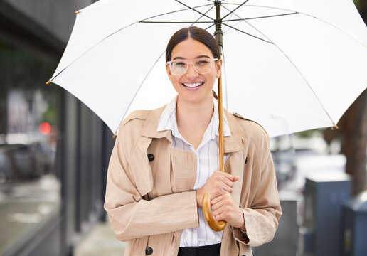 Smiling Business woman with an umbrella on the sidewalk