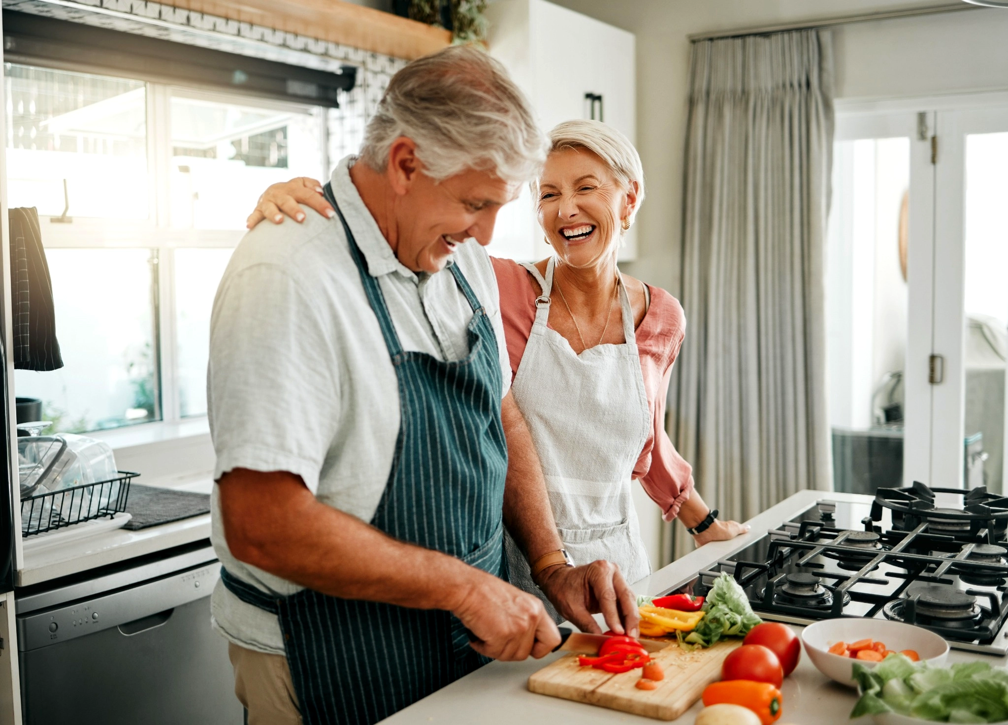 Older couple having fun cooking together in the kitchen