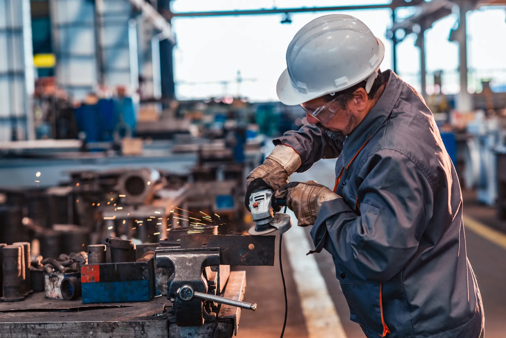 Skilled industrial worker grinding metal part..jpg